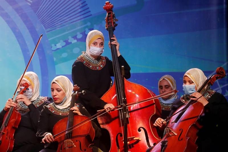 Members of Al-Nour Wal Amal (Light and Hope) chamber orchestra of blind women wearing protective masks play during their first concert. (Reuters Photo)